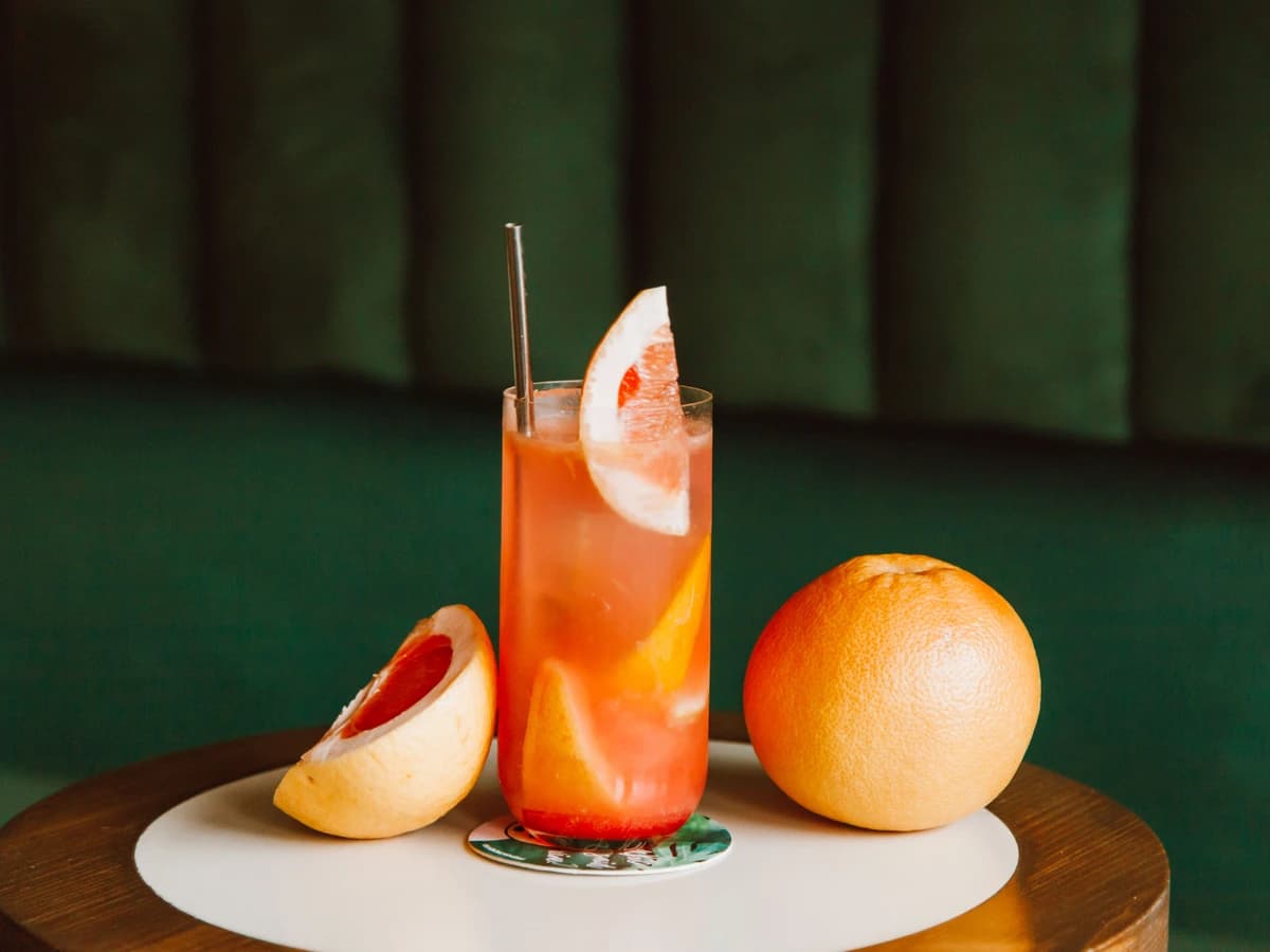 An Alcohol-Free Paloma in a salt-rimmed highball glass with a grapefruit wedge