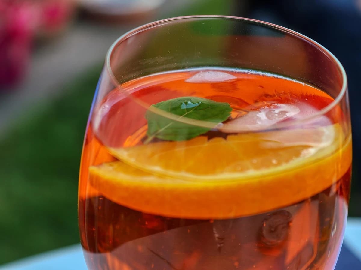 An alcohol-free spritz in a wine glass with an orange wheel and soda bubbles