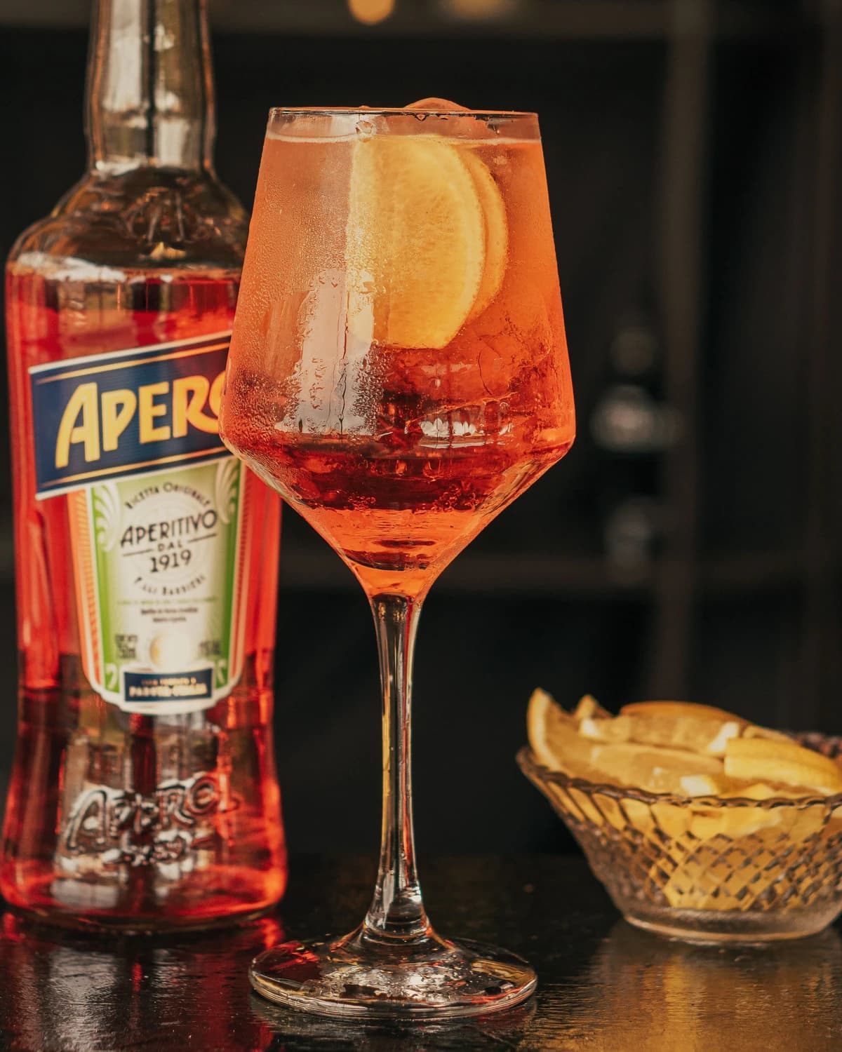 An Aperol Spritz in a large wine glass with an orange slice