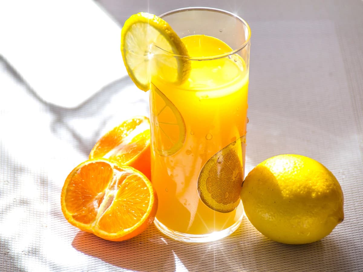 A Citrus Cooler in a highball glass with mint sprig and orange wheel