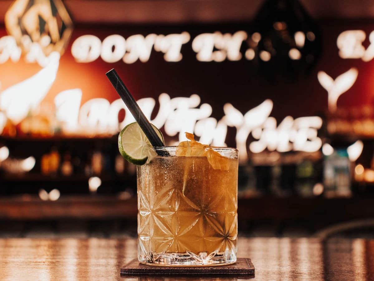 A Dark 'n' Stormy in a highball glass showing the dark rum floated over pale ginger beer