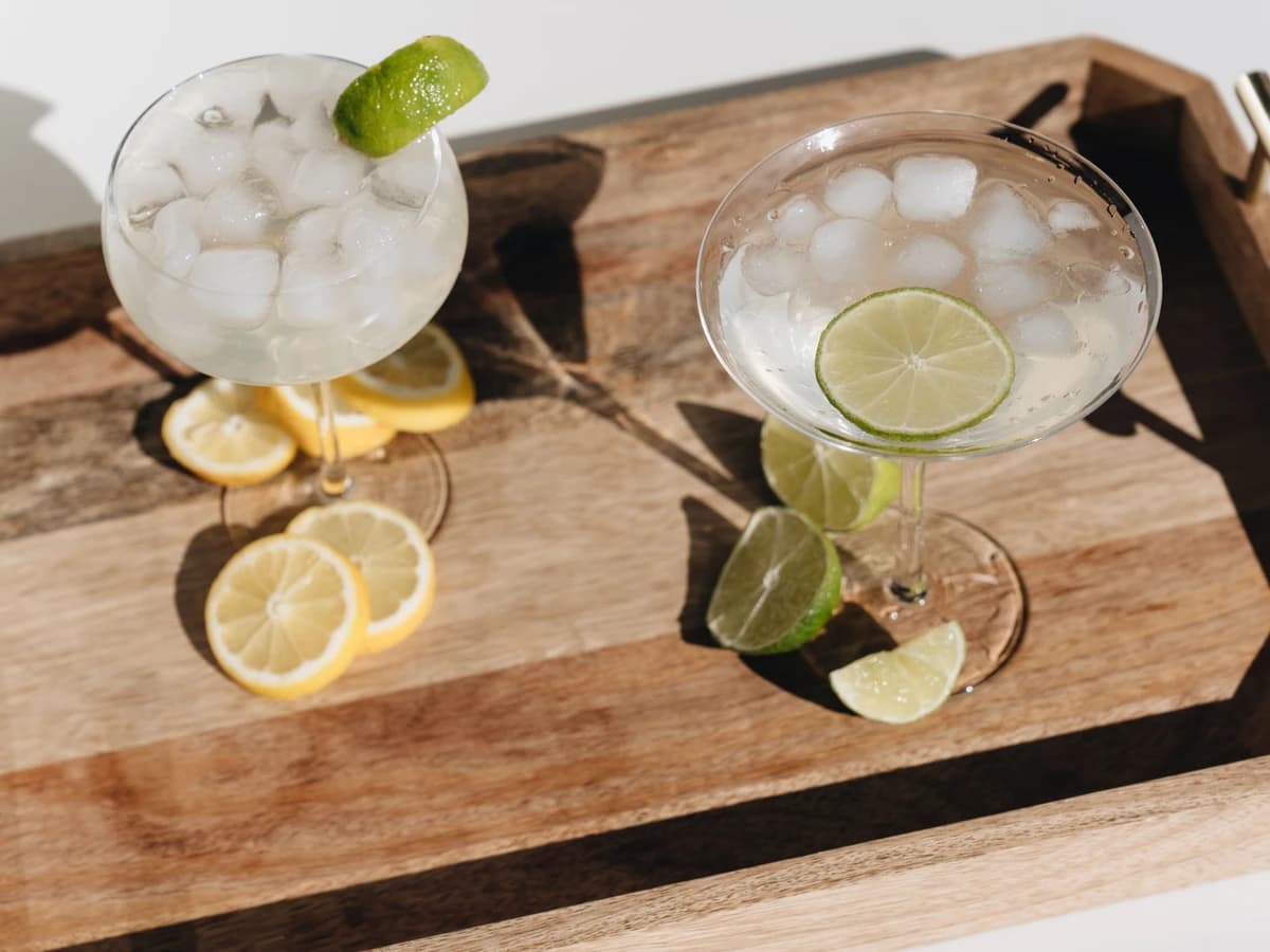 A Gimlet in a coupe glass with a pale green tint and a lime wheel garnish