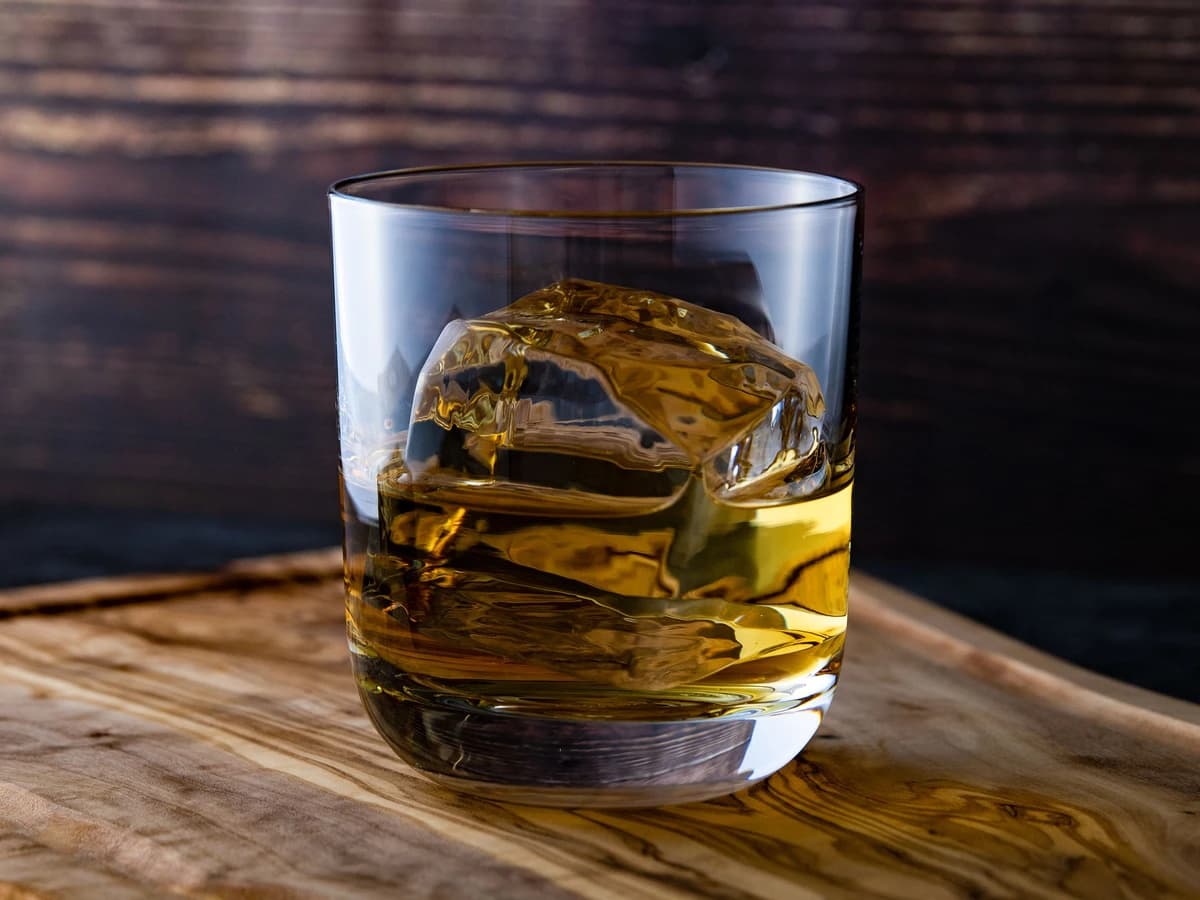 A Godfather cocktail in a rocks glass with a single large ice cube