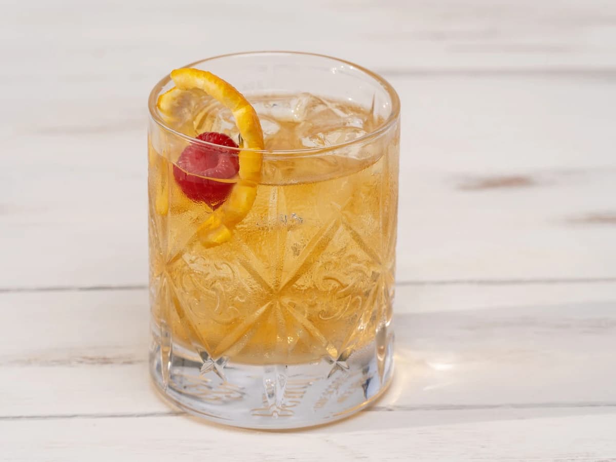 A Godmother cocktail in a rocks glass with a single large ice cube