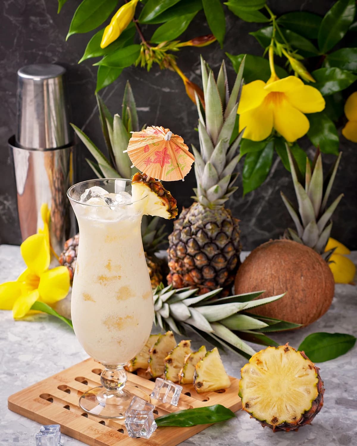 A blended Piña Colada in a hurricane glass with a pineapple wedge and cherry