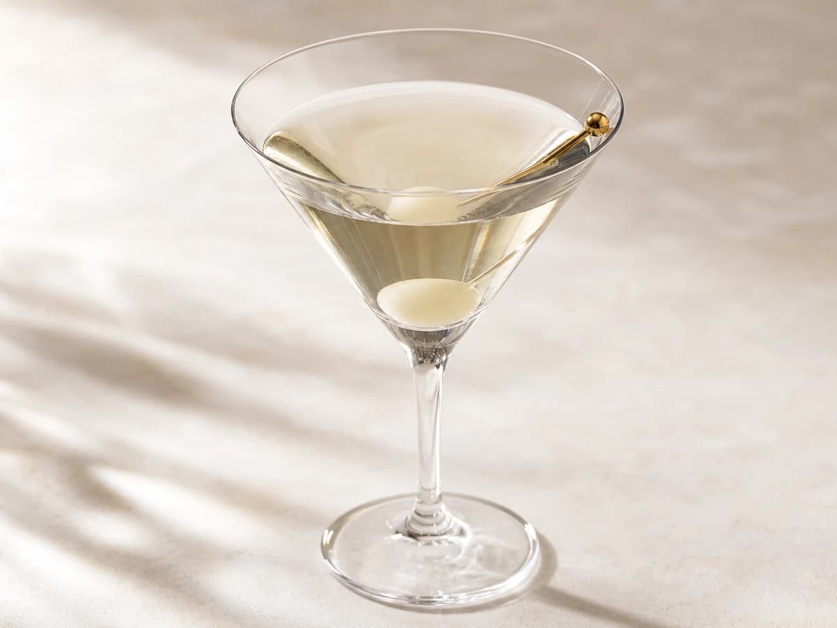 A Gibson cocktail in a chilled glass garnished with a pickled cocktail onion