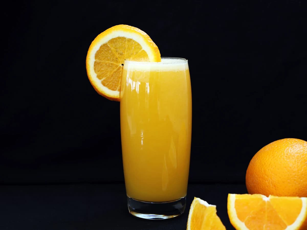 A Screwdriver in a highball glass with an orange slice