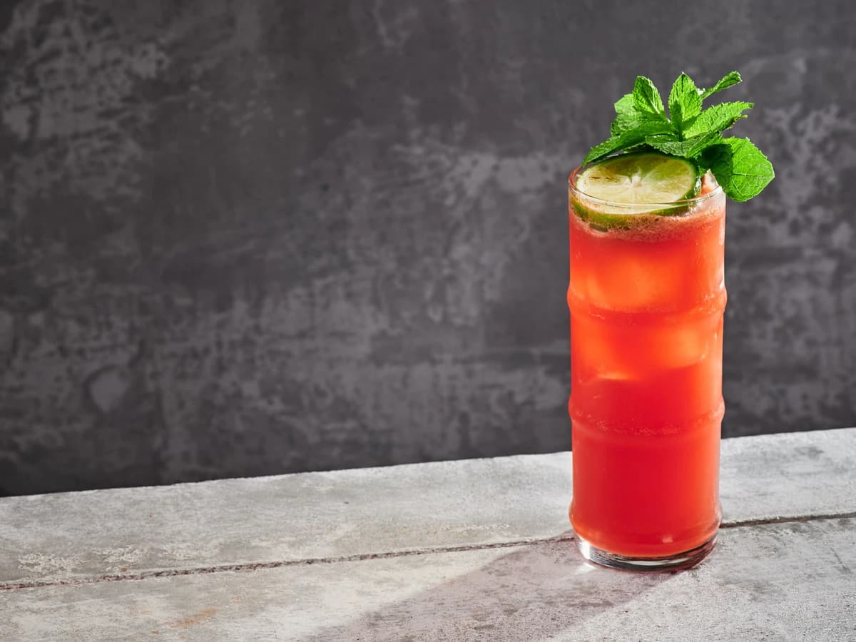 A tall Zombie cocktail in a tiki mug with crushed ice and a mint garnish